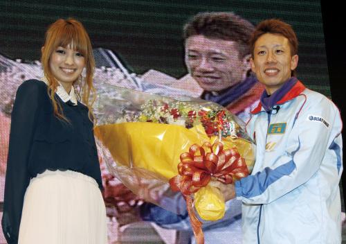 第26回新鋭王座決定戦で優勝し、イメージガールの南明奈（左）から花束を受け取り笑顔を見せる松尾昂明