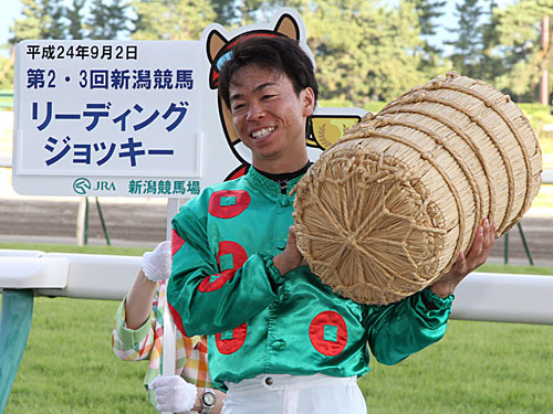 第２・３回新潟競馬リーディングジョッキーに輝いた北村宏司騎手は米俵を担ぎポーズ