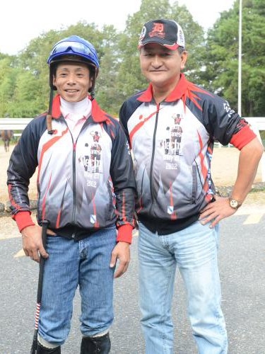 ディープブリランテの調教後、おそろいのジャンパーに身を包み笑顔を見せる矢作調教師（右）と岩田