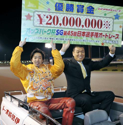 優勝し賞金ボードを掲げる木村武之。右はプレゼンターの小川直也氏