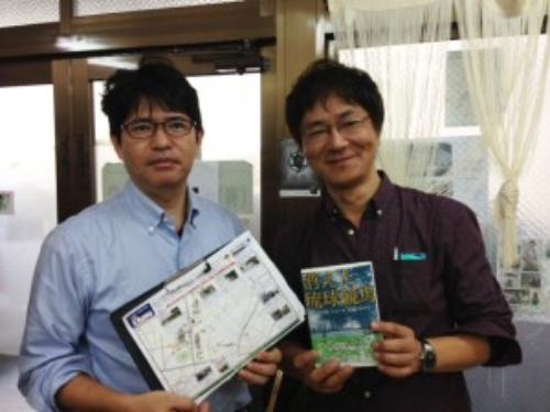 受賞作を掲げる梅崎記者（右）と担当編集者・新城和博氏
