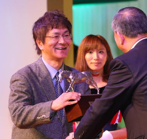ＪＲＡ・土川理事長（右）から馬事文化賞のトロフィーを受け取るスポニチ・梅崎記者