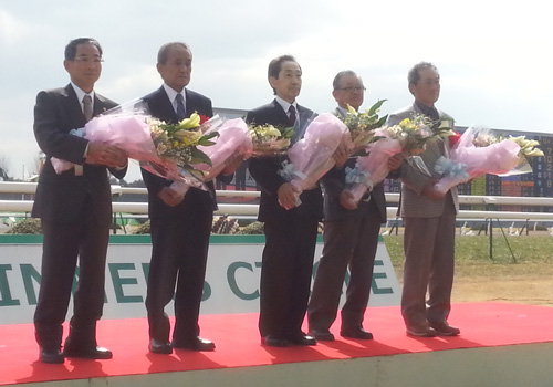 引退セレモニーで花束を手に並ぶ（左から）飯田明弘、鹿戸明、武宏平、野村彰彦、藤岡範士の各調教師