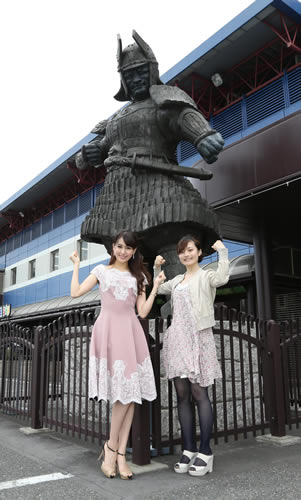 ボートレース江戸川の入場口にある大魔神像の前でポーズをとるミス日本グランプリの沼田萌花さん（左）と「ボートレースラジオガールズ」のパーソナリティーの野口逢里さん（C）１９６６角川映画