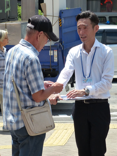 ＪＲ船橋駅前で署名活動に汗を流す永井（右）