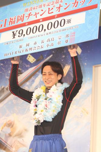 ９００万円の賞金ボードを掲げ、笑みを見せる山崎
