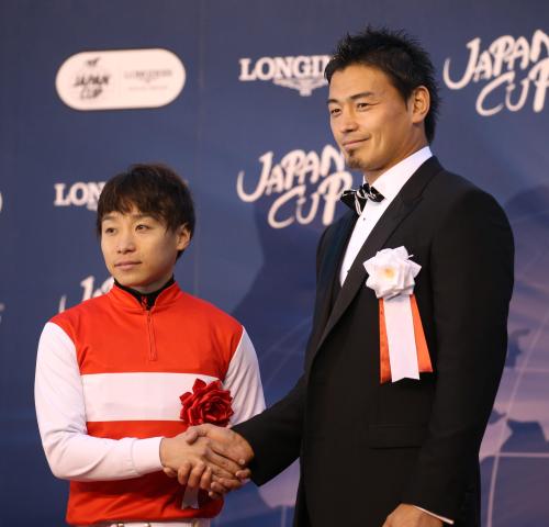 ＜東京１１Ｒ・ジャパンＣ＞レースを制した池添（左）はプレゼンターを務めた五郎丸と握手を交わす