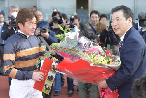 橋口弘次郎調教師に涙を流しながら花束を渡す小牧太騎手（左）