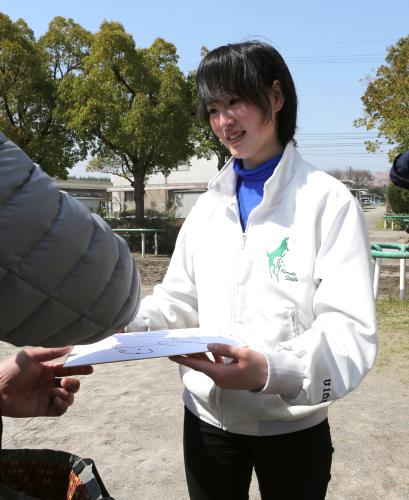 根本厩舎に来た見学者の色紙にサインする藤田菜七子騎手