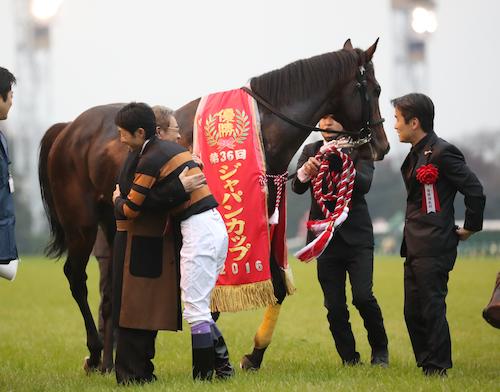 ＜ジャパンＣ＞レースを制したキタサンブラックの武豊と北島オーナーは愛馬を前に笑顔で抱き合う。右は清水久師