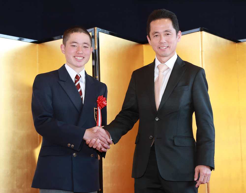 卒業式を終え父・武藤善則師（右）と笑顔で握手する雅