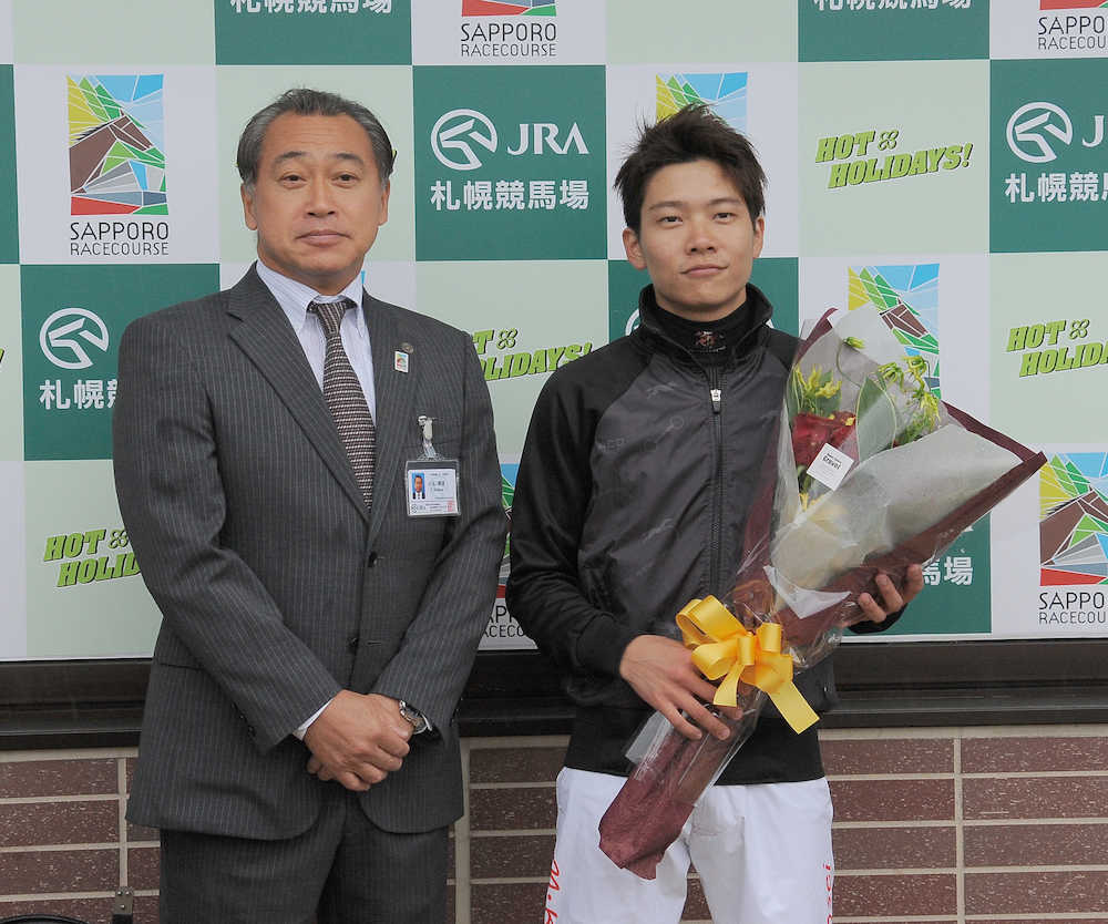 長いブランクの末に札幌でレースに復帰し、札幌競馬場の小玉剛資場長（左）から花束を受ける三浦皇成騎手