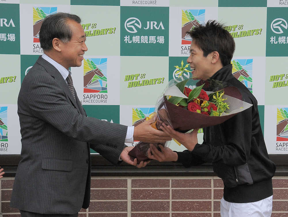 レースに復帰して札幌競馬場の小玉剛資場長（左）から花束を受ける三浦