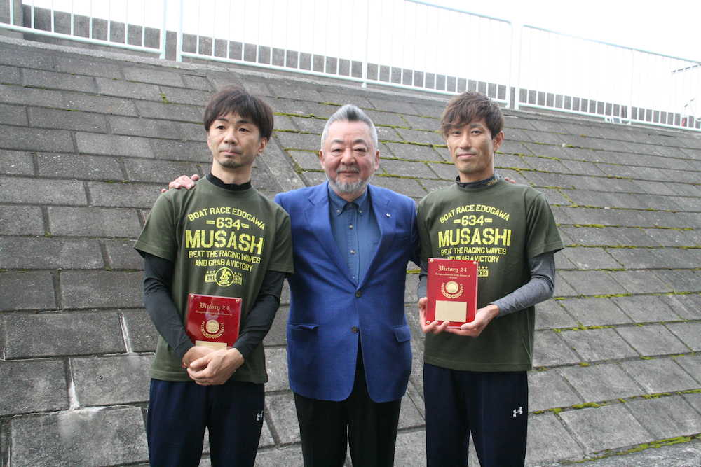 全国２４場制覇を達成し、ボートレース振興会の小高幹雄会長（中央）から記念の盾を授与された辻（左）と原田（右）