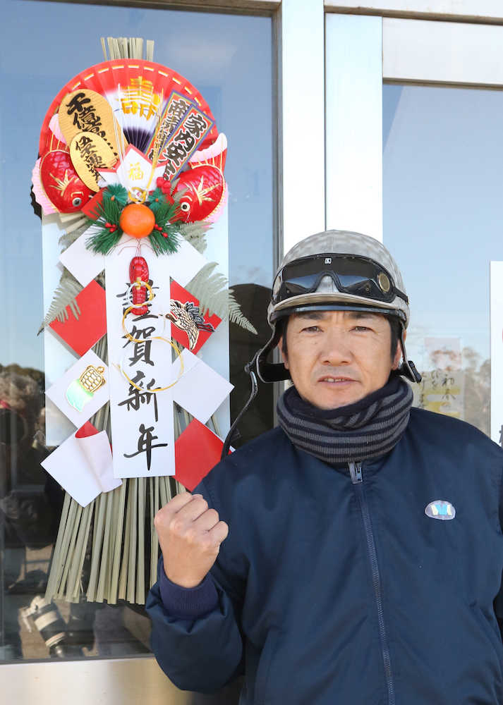今年年男の田中勝は正月飾りの前でガッツポーズ（撮影・郡司　修）