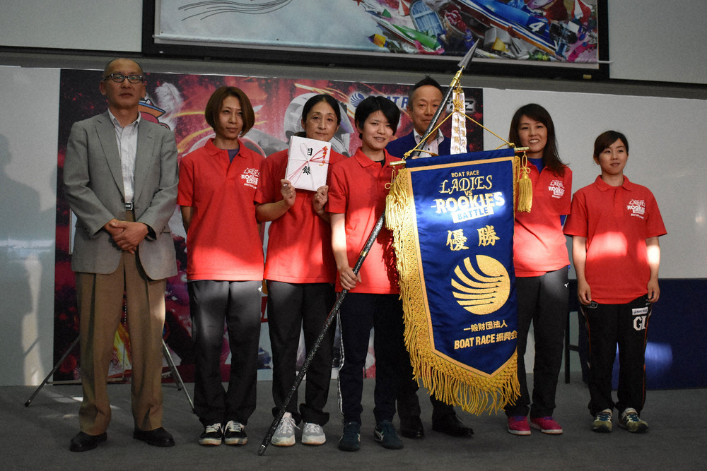 優勝旗を手に笑顔の紅組団長・遠藤（中央）と紅組の選手