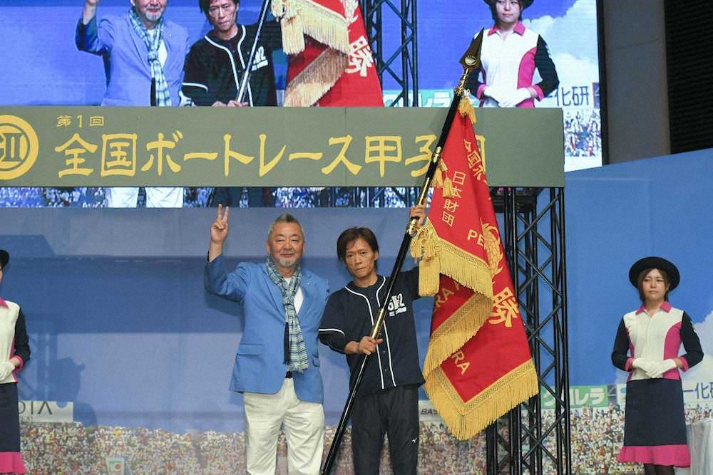 日本財団笹川陽平会長に代わり、優勝旗を授与したBOATRACE振興会小高幹雄会長（左）と初代王者の今垣