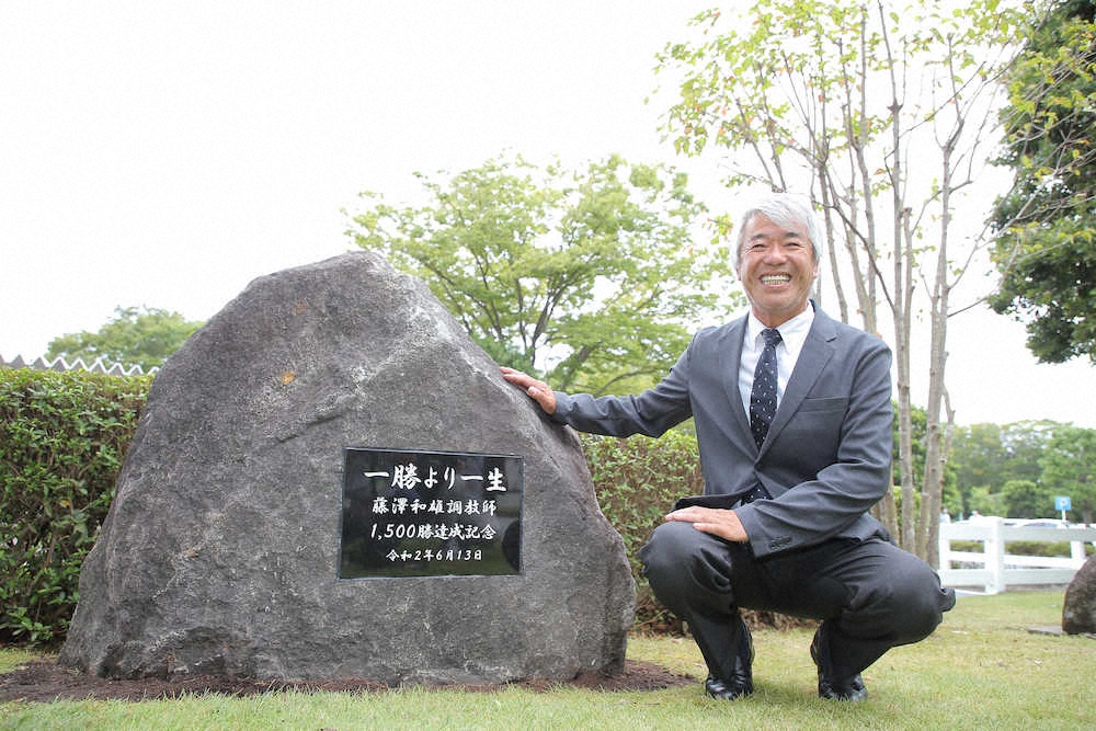 1500勝達成記念碑の横で笑顔の藤沢和雄調教師