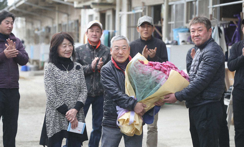引退する星野師（中央）とみゑ子夫人（中央左）は土田厩務員（中央右）から厩舎カラーの紫のバラ100本の花束を贈られる　（撮影・西川祐介）