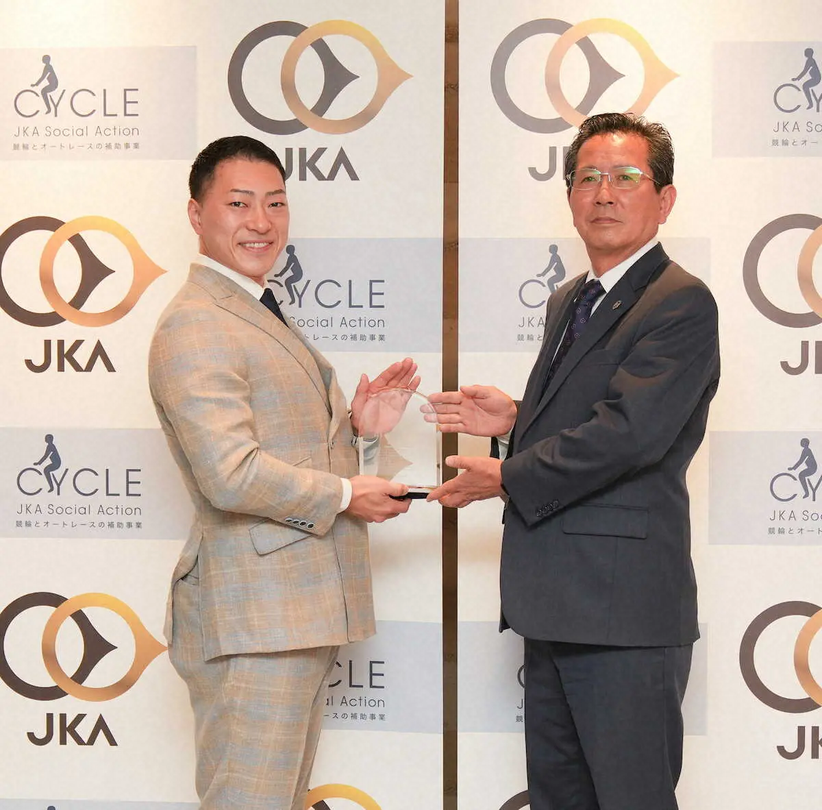 【画像・写真】笹部俊雄JKA会長（右）から記念品を贈呈される新田（JKA提供）