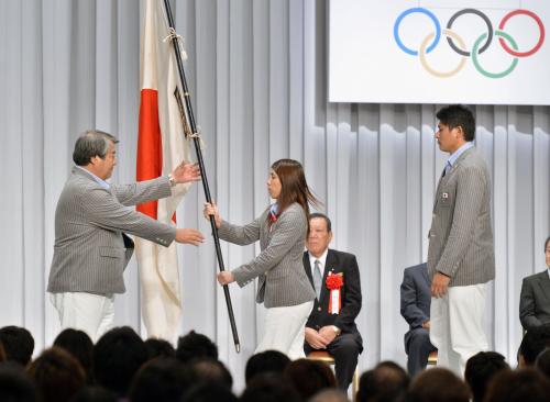 ロンドン五輪の日本選手団解団式で、上村春樹団長（左）に団旗を返還する旗手の吉田沙保里。右は村上幸史主将