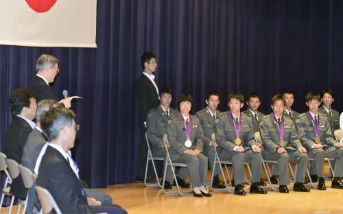 防衛省で開かれた帰国報告会に出席した（前列左から）小原日登美、米満達弘、湯元進一、清水聡の各選手。左奥は森本防衛相