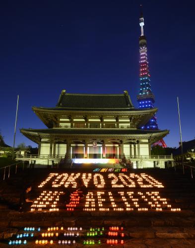 増上寺の境内にキャンドルで浮かび上がった、２０２０年夏季五輪の東京開催を願うメッセージ。後方は五輪カラーにライトアップされた東京タワー
