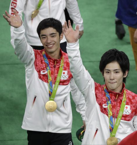 金メダルをかけ笑顔で声援に応える白井（左）と加藤（ＡＰ）