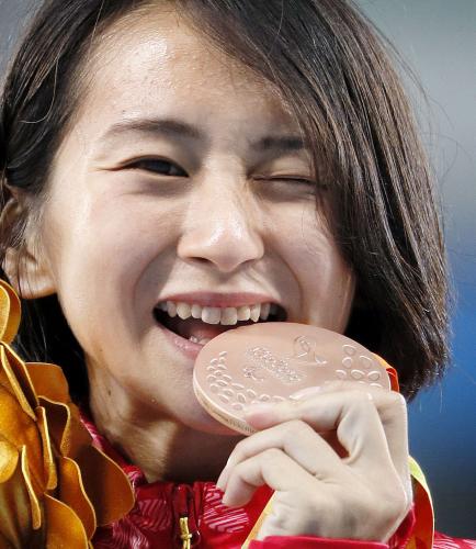 ＜女子４００メートル決勝（切断などＴ47）＞獲得した銅メダルをかむ辻沙絵