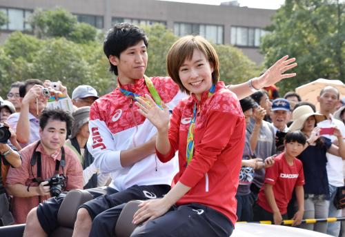 合同凱旋パレードで手を振る、リオ五輪卓球男子団体銀メダリストの吉村真晴選手（左）と同女子団体銅メダリストの石川佳純選手