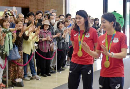 徳島県庁を訪れ、出迎えの人たちに笑顔で応えるリオ五輪バドミントン女子ダブルス金の松友美佐紀選手（右）と高橋礼華選手