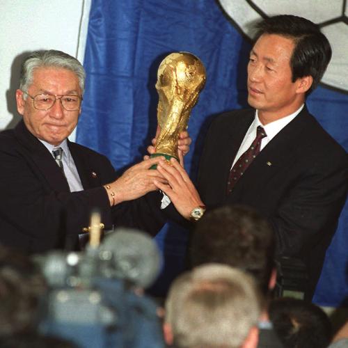 ９６年５月、日韓共催が決定しＷ杯のトロフィーを掲げる長沼健・日本サッカー協会会長（左）と鄭夢準・韓国サッカー協会会長