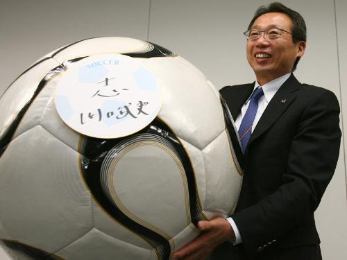 今年の抱負「志」が張られた巨大サッカーボールを掲げ、笑顔を見せる