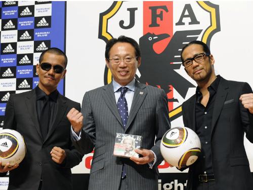 サッカー日本代表の応援歌を手掛けるＥＸＩＬＥのＨＩＲＯさん（右）、ＡＴＳＵＳＨＩさん（左）とガッツポーズする岡田監督