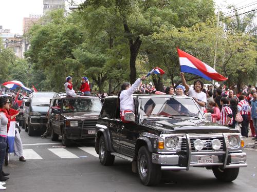 日本を破って初の８強入りを決めたパラグアイの首都アスンシオンで、国旗を掲げて行進する市民