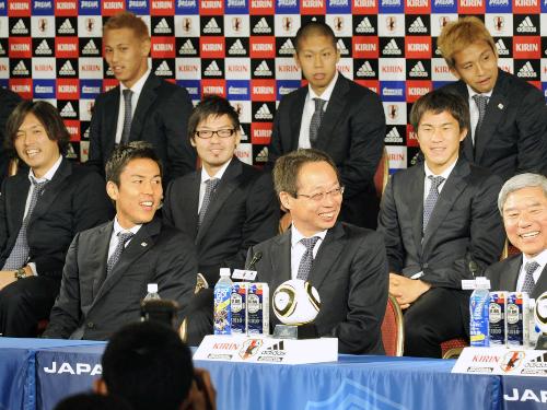 サッカーＷ杯に出場し、南アフリカから帰国して記者会見する日本代表の岡田監督（前列中央）と選手ら。上段左は本田