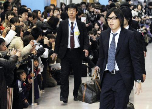 大勢のファンが待ち受けるなか、関西空港に到着したサッカー日本代表の遠藤保仁（右）