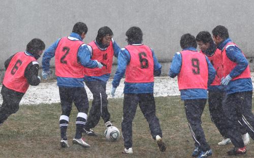 あまりの寒さに、体を寄せ合うようにしてボールまわしする川崎Ｆの中村憲（左から３人目）ら選手たち