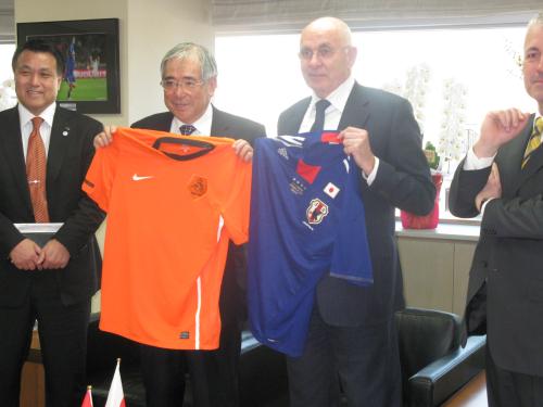 日本サッカー協会を訪れたオランダサッカー協会のファンプラーグ会長（中央右）と小倉会長（同左）はユニホームを交換