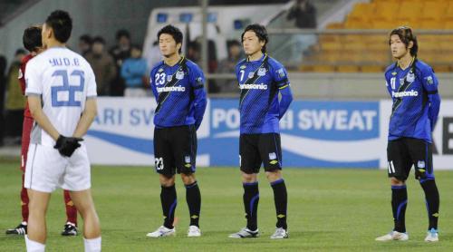 天津との試合前、東日本大震災の犠牲者を悼み、黙とうする（右から）Ｇ大阪の宇佐美、遠藤ら