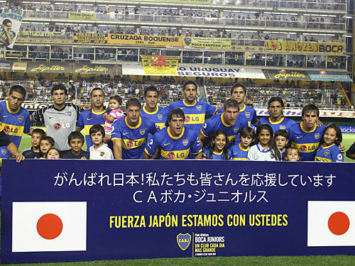 日本を支援するメッセージが書かれたボードを掲げたボカの選手たち