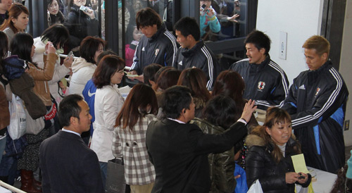 多くのファンが訪れる中、募金活動する本田圭（右）ら日本代表