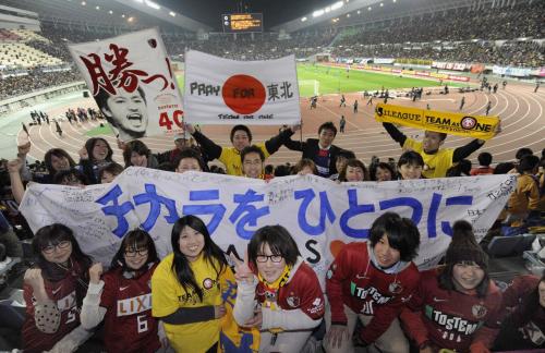 サッカーの慈善試合が行われる長居陸上競技場で、東日本大震災の被災者への応援メッセージを掲げる仙台と鹿島のサポーター
