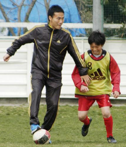被災地を訪れ、子どもとサッカーをする日本代表の今野