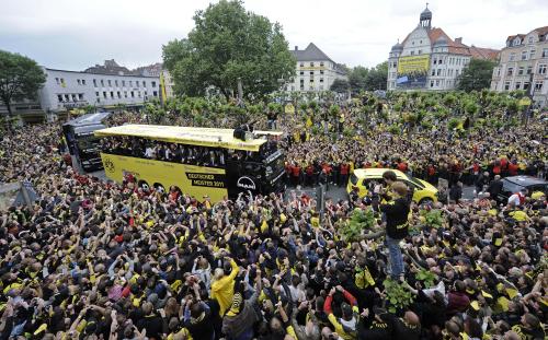 沿道に集まった大勢のファンの中を進む、優勝したドルトムントの選手らを乗せたバス