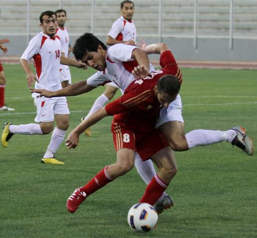 ７月２３日、Ｗ杯予選でシリアの選手（手前）と競るタジキスタンの選手（ＡＰ）