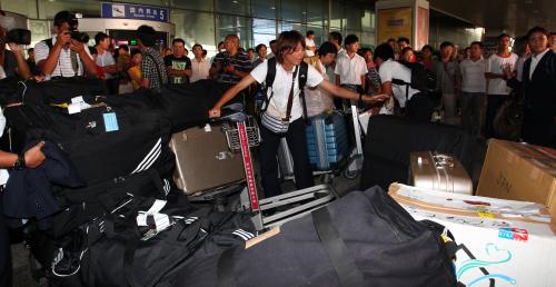 ＜なでしこジャパン移動＞済南空港に到着し、地元メディアに囲まれながら、荷物を片づける熊谷