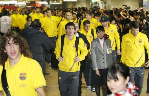 ファンの歓声を浴びながら成田空港の通路を移動するメッシ（中央）らバルセロナのイレブン