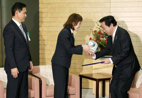 日本プロスポーツ大賞の内閣総理大臣賞を受賞し、野田首相にサインボールを贈る「なでしこジャパン」の丸山桂里奈選手。左は佐々木則夫監督