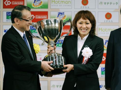 日本プロスポーツ大賞表彰式で、内閣総理大臣杯を手に笑顔を見せる「なでしこジャパン」の丸山桂里奈選手。左は中川文科相